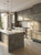 A large kitchen island transformed with a dark concrete vinyl wrap, showcasing a modern industrial interior design.