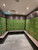 Wide view of a commercial gym locker room featuring rows of lockers completely transformed with the durable Matte Textured Forest Green vinyl wrap.