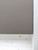 Close-up detail of a flat-panel kitchen cabinet flawlessly wrapped in Layed Matte Silk Brown Grey vinyl, positioned beautifully above a white speckled surface.