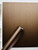 A roll of Layed Brushed Metal Bronze Vinyl Wrap resting against a modern flat-panel cabinet that has been seamlessly wrapped in the exact same dark metallic film.