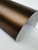 A close-up view of Layed Brushed Metal Bronze Vinyl Wrap partially peeled back to reveal its self-adhesive backing and rich, textured metallic face.