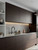 A contemporary kitchen featuring sleek, flat-panel upper and lower cabinets beautifully transformed with Layed Macassar Ebony Wood Vinyl Wrap, paired perfectly with matte black fixtures.