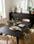 A stylish, modern dining room featuring a large dining table and a matching long sideboard flawlessly upgraded using Layed Macassar Ebony Wood Vinyl Wrap.