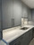 Sleek, contemporary kitchen cabinetry completely upgraded with the tactile, woven look of Layed Graphite Linen Fabric Vinyl Wrap, contrasting beautifully with bright white quartz countertops.