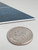Cutting peel and stick marine blue composite tiles to size using a knife and ruler during installation