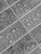 Detailed close-up texture of dark grey slate-effect wall tiles showing realistic stone grain and white grout lines