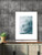 Decorative living room accent wall with dark grey vertical tiles behind a wooden cabinet and framed abstract art