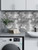 Industrial-style kitchen featuring a full wall of silver aluminium hexagon composite tiles for a professional stainless steel finish.