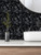 High-resolution texture shot of brushed matte black metal hexagon tiles showing light-catching industrial finish.