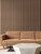 High-contrast interior design featuring Smoked Walnut wood slats installed behind a tan velvet sofa and a terrazzo coffee table.