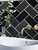Bathroom renovation using Onyx Black Herringbone peel and stick tiles.