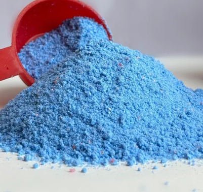 Illustrative photo of blue detergent powder and a scoop; actual 25 lb packaging not shown.
