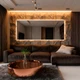 UltraBright™ Sienna Dim-to-Warm IP20 LED Strip creating a warm halo backlight around a living room wall mirror.