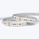 Coiled ColorBright™ RGBW Quad Chip White IP20 LED Strip with a silicon-coated circuit board and 3M adhesive backing.