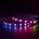 ColorBright™ RGB Digital Pixel IP20 LED Strip illuminated in various hues at the same time while coiled on a reflective dark surface.