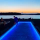 Outdoor ColorBright™ RGB 300 IP65 LED Strip installed under wooden deck top rails for blue accent light.