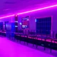 Roller rink hallway lit by bright magenta linear ColorBright™ RGB 600 IP20 LED Strip ceiling accents.
