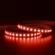 ColorBright™ RGB 600 IP20 LED Strip illuminated in red, green, and blue, while coiled on a reflective dark surface.