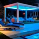 ColorBright™ RGB + Dynamic Tunable White IP65 LED Strip Light illuminating a modern poolside pergola light blue at night.