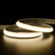 Valor™ Diffused IP67 LED Strip illuminated in a seamless warm glow while coiled smoothly on a dark reflective surface.