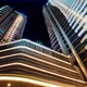 Warm Valor™ Diffused IP67 LED Strips outline curved exterior architecture on high-rise buildings against the night sky.