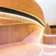 UltraBright™ Industrial IP20 LED Strips illuminate curved wooden walls and stairs in a modern grand hall architecture.