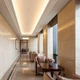 A luxurious hotel hallway and armchairs illuminated by UltraBright™ Architectural IP20 LED Strips in a warm white ceiling cove.