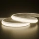Outdoor UltraBright™ Verity SOB Diffused IP65 LED Strip lighted in soft 3000K warm white, coiled on a reflective surface.