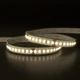 Outdoor UltraBright™ Architectural IP65 LED Strip illuminated in a soft 3000K warm white glow while coiled on a reflective surface.