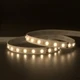 UltraBright™ Architectural Dynamic Tunable White IP20 LED Strip illuminated in various whites while coiled on a reflective surface.