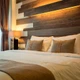 UltraBright™ Outline IP20 LED Strips integrated into staggered wood panels for a warm, ambient, and modern bedroom design.
