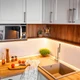 Warm UltraBright™ Outline IP65 LED Strips provide bright under-cabinet task lighting in a rustic kitchen with wood counters.