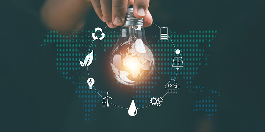 Hand holding a glowing light bulb symbolizing global energy innovation and sustainability.