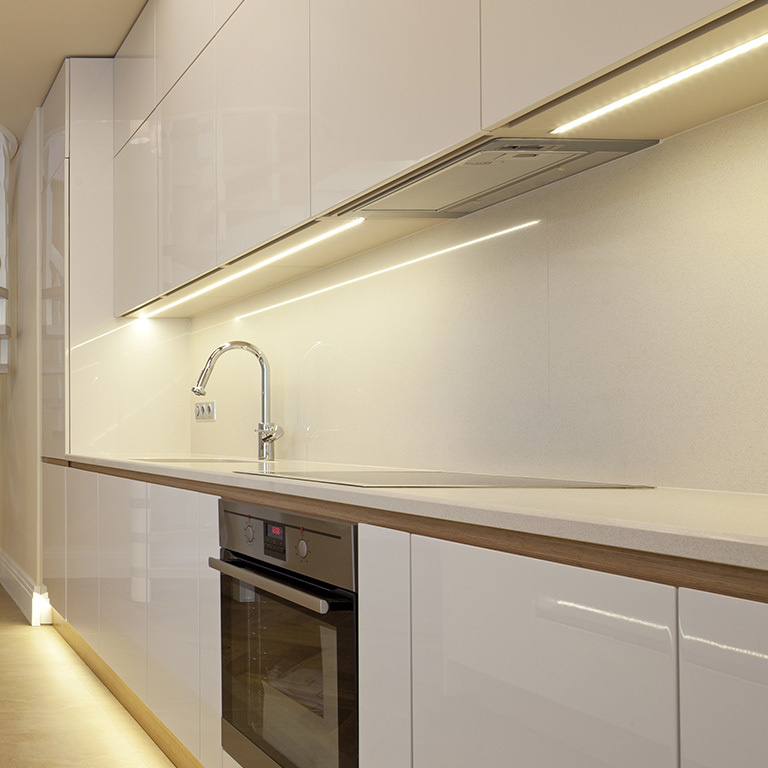 Kitchen with white cabinetry and undercabinet LED lighting