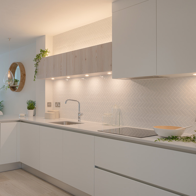 Kitchen with white cabinetry and under cabinet LED puck lights