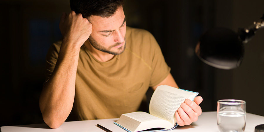 Person reading under white light lamp