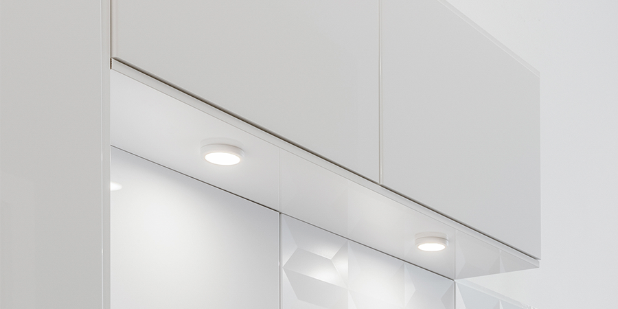 Kitchen with Victory Select LED puck mounted lights under white cabinets illuminating countertop