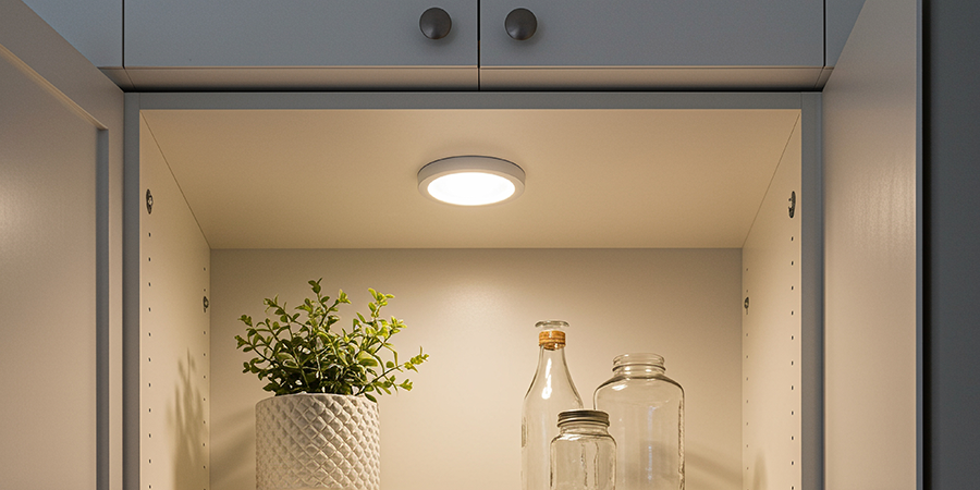 Victory Select LED puck lights mounted under cabinet illuminating kitchen workspace.