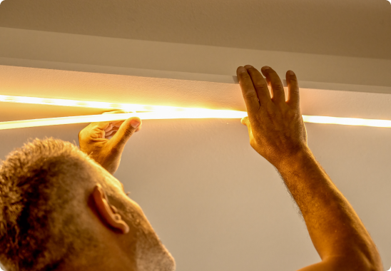 A man opening a wine cabinet with white LED linear lighting turning on automatically inside.