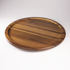 An angled view of the empty Acacia Lazy Susan, highlighting the beautiful, rich grain and warm tones of the natural acacia wood and its raised edge design.