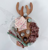 The Antler board is presented as a festive charcuterie display, artfully arranged with a variety of cured meats, cheeses, fruits, and crackers, perfect for holiday entertaining.