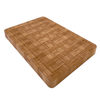 A bamboo end grain cutting board viewed at an angle, emphasizing its thickness and the perimeter well designed to catch liquids.