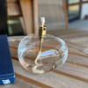 A close-up of the lit table top torch, showcasing the beautiful glow of the flame and the clear, hand-blown glass design of the oil reservoir.