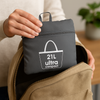 A hand is shown easily placing the folded and packed Navigator Tote pouch into a larger travel bag, demonstrating its convenient, space-saving packability.