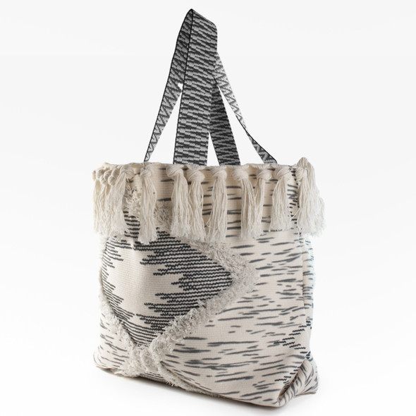 An angled, three-quarter view of the Lola Tassels Large Boho Tote, highlighting its textured woven design and comfortable shoulder straps. An angled, three-quarter view of the Lola Tassels Large Boho Tote, highlighting its textured woven design and comfortable shoulder straps.