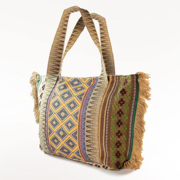 A three-quarter view of the Isla Fringe tote bag, highlighting its unique, multi-patterned design and comfortable woven shoulder straps.