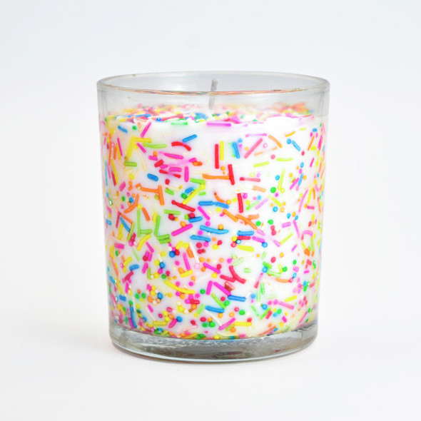 A clear product shot of the sprinkles inclusion candle against a plain white background, highlighting the dense, multi-colored sprinkles suspended in the white soy wax. A clear product shot of the sprinkles inclusion candle against a plain white background, highlighting the dense, multi-colored sprinkles suspended in the white soy wax.