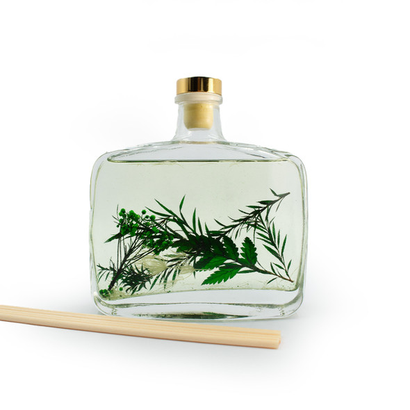 A clear, isolated product shot of the Dream Garden diffuser against a plain white background, showing the square glass bottle with its botanical inclusions and a single reed placed beside it. A clear, isolated product shot of the Dream Garden diffuser against a plain white background, showing the square glass bottle with its botanical inclusions and a single reed placed beside it.