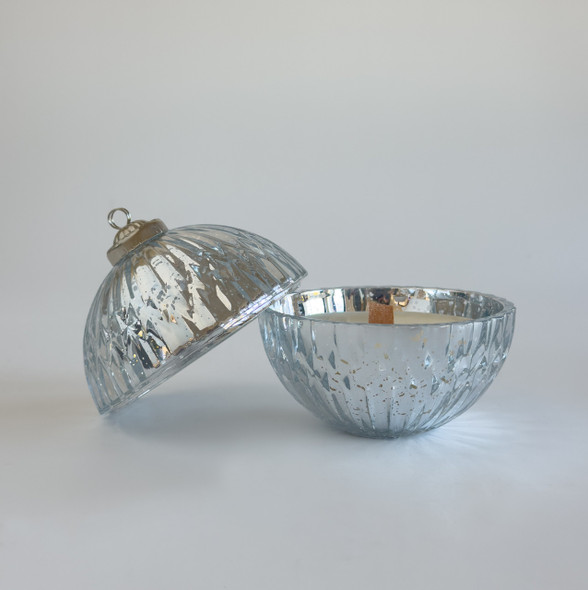 The two-piece mercury glass ornament candle is shown open against a white background, with the top half next to the bottom half which contains the unlit wood wick candle.