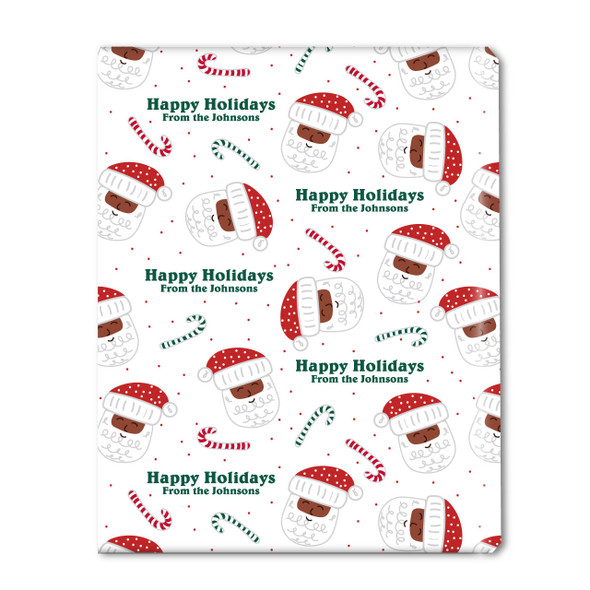 A flat swatch of the custom holiday wrapping paper, clearly showing the pattern of diverse Santa heads, candy canes, and the personalized "Happy Holidays, From the Johnsons" greeting.